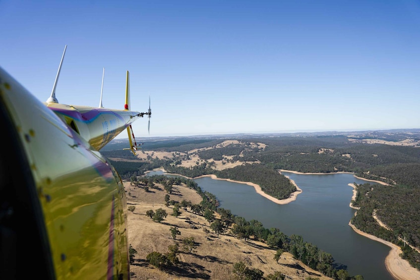 An airplane wing with a clear view of a river and surrounding landscape. 2