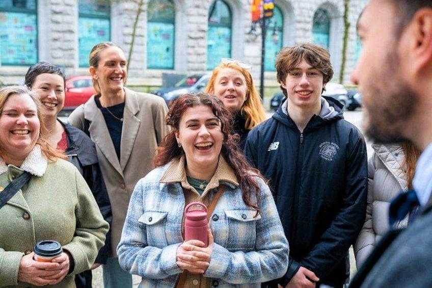 Un gruppo di persone che cammina su una strada con edifici in pietra sullo sfondo. 1