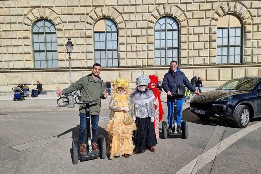 Een groep mensen op hoverboards voor een historisch gebouw met boogvensters. 4
