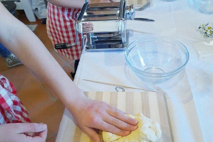 A person kneading dough on a wooden board with a rolling pin nearby. 2