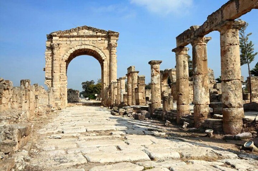 Ancient ruins with a large stone archway and columns. 3