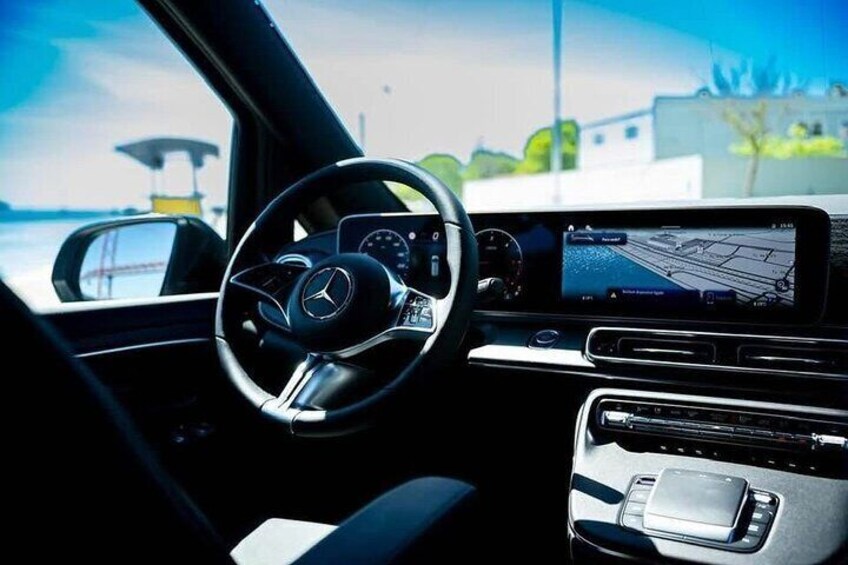 El interior de un coche con volante, tablero y pantalla de navegación. 2