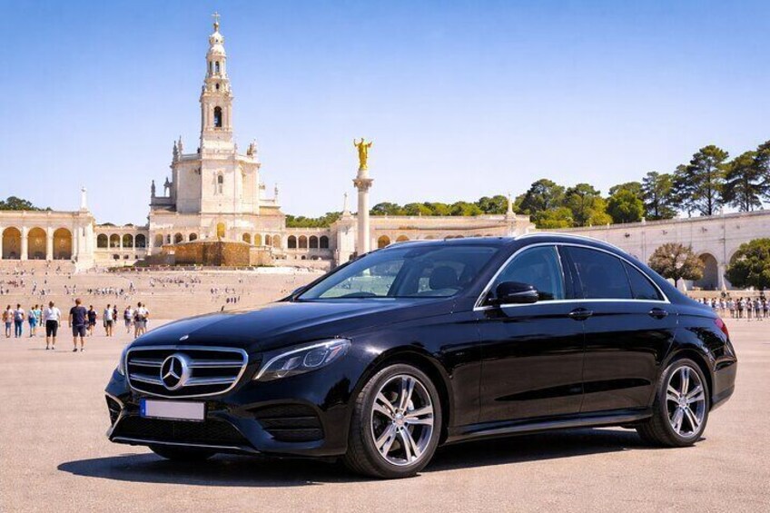 Un Mercedes-Benz negro estacionado frente a un edificio histórico con una torre alta y arcos. 4