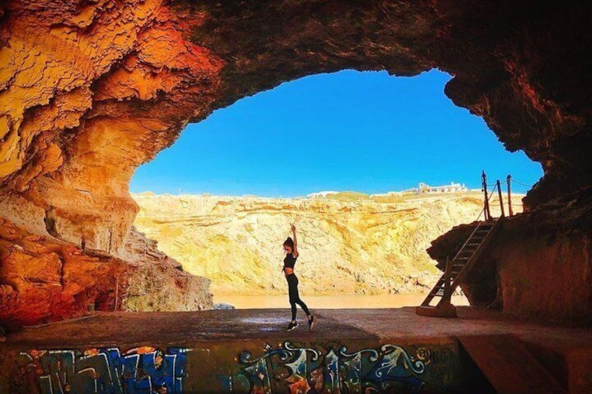Une personne se tient dans une grotte, d’où l’on peut admirer un paysage désertique. 4