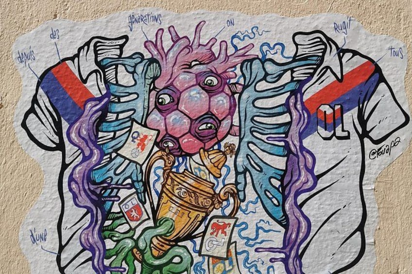 A colorful graffiti artwork on a wall featuring a figure with a heart-shaped head, a trophy, and playing cards. 4