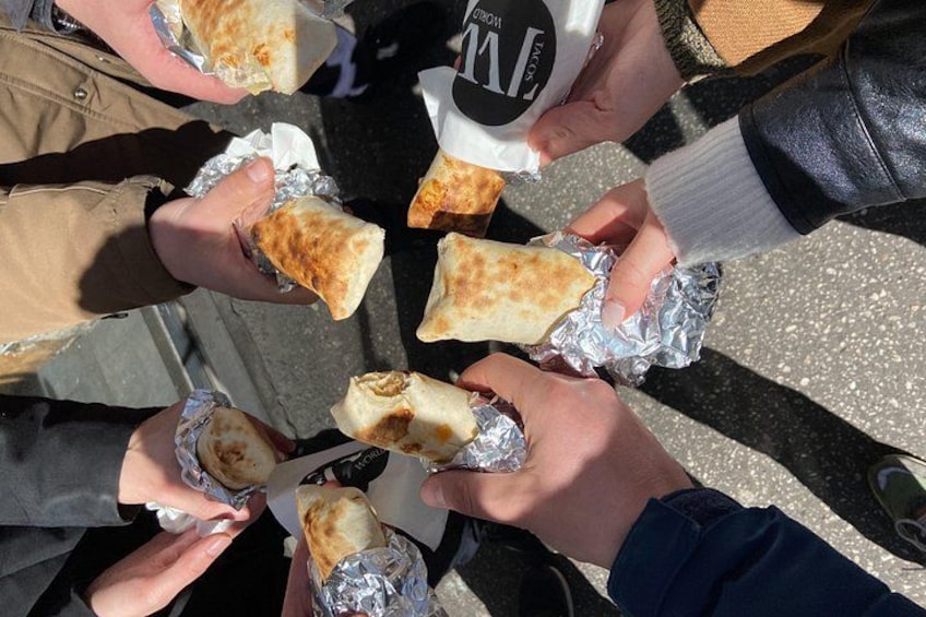 People holding food wrapped in foil. 1