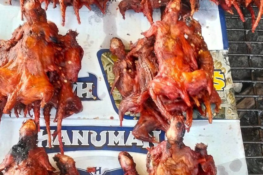 A display of cooked chickens with a sign in the background. 3