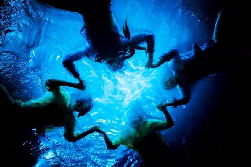 An underwater scene with people swimming in a circular formation. 2