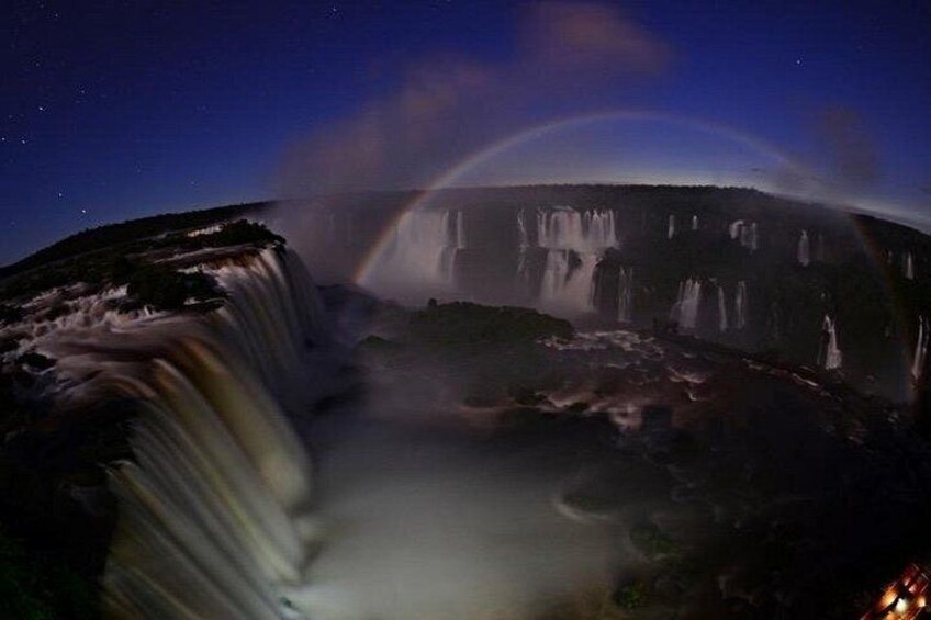 A waterfall at night with a visible rainbow. 2