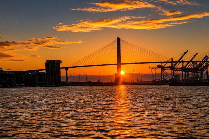 Un atardecer sobre un puente con agua debajo. 4