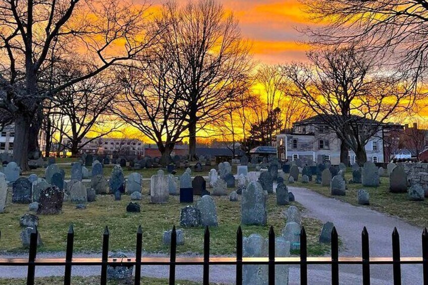 A cemetery at sunset with tombstones and trees. 3