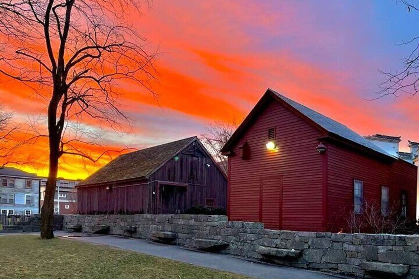 A red barn and a smaller wooden structure at sunset. 4