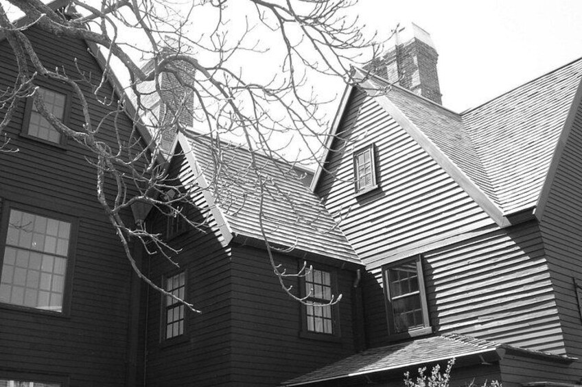A wooden house with a steeply pitched roof and a chimney. 2