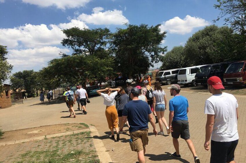A group of people walking on a paved path in a park. 2