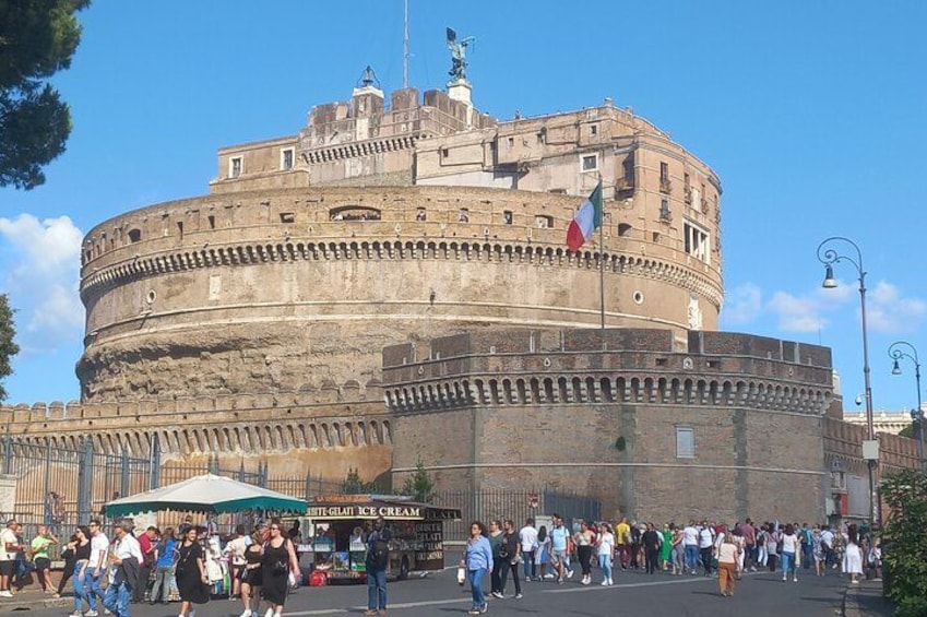Une forteresse de pierre historique, surmontée d’un drapeau, et entourée d’une foule de personnes. 3