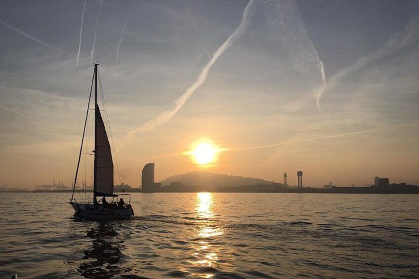 Un voilier sur une eau calme, avec un coucher de soleil en arrière-plan. 2