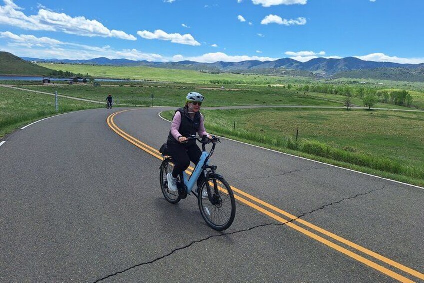 Un ciclista en un camino sinuoso con un paisaje pintoresco al fondo. 5