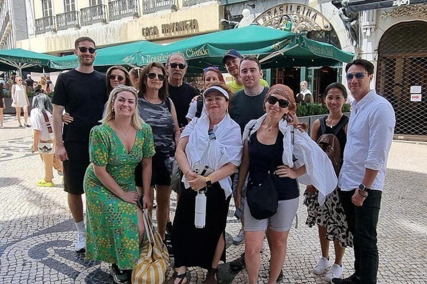 Een groep mensen poseert voor een restaurant met terras. 4