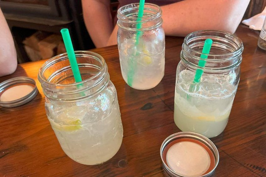 Three mason jars with green straws on a wooden table. 4
