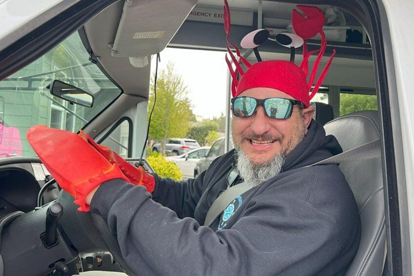 A person in a vehicle wearing a red crab costume and holding a red glove. 5