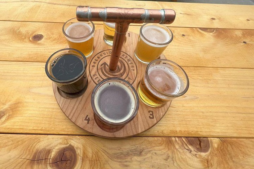 A wooden beer tap with four glasses on a wooden board. 3