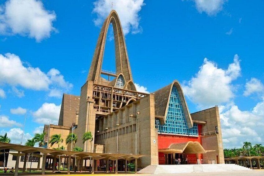 A large, modern building with a prominent arch structure and a blue-tinted window. 5