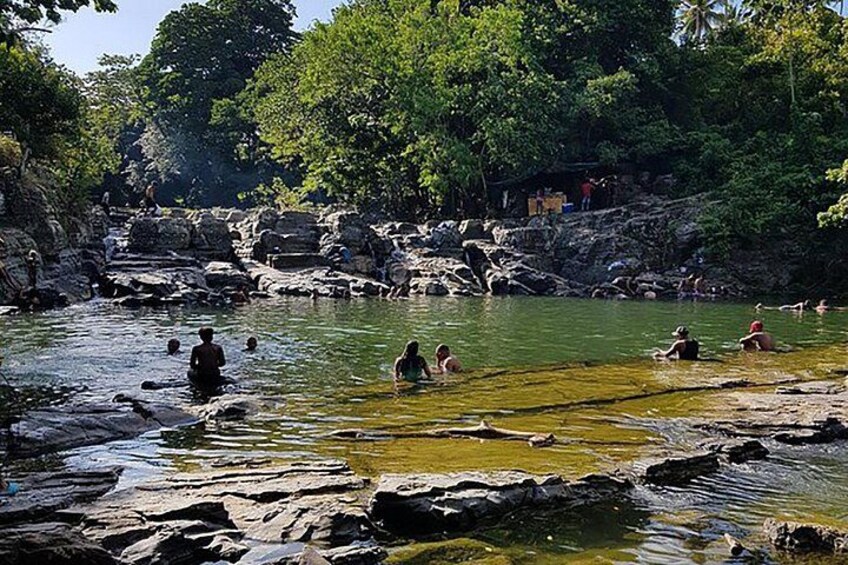 A natural water body surrounded by rocks and trees. 2