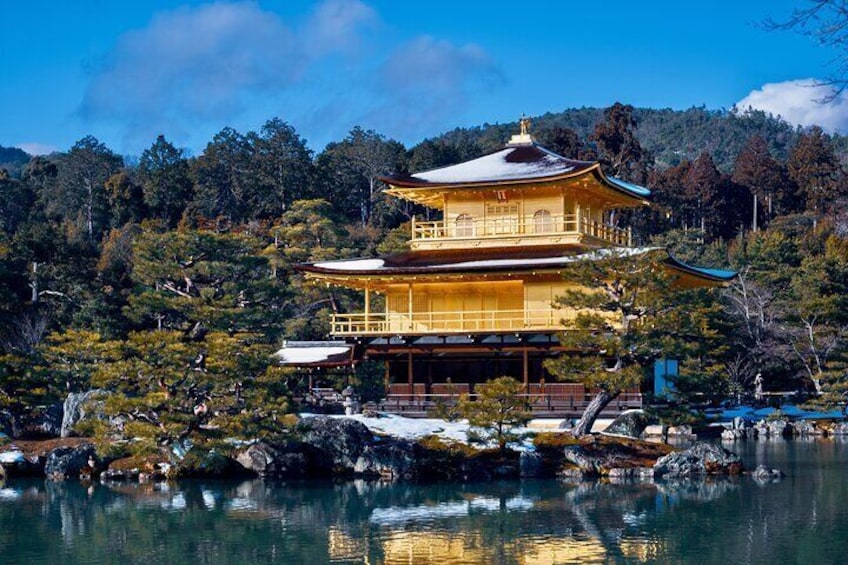 A traditional Japanese temple with a multi-tiered roof, surrounded by a serene lake and lush greenery. 1