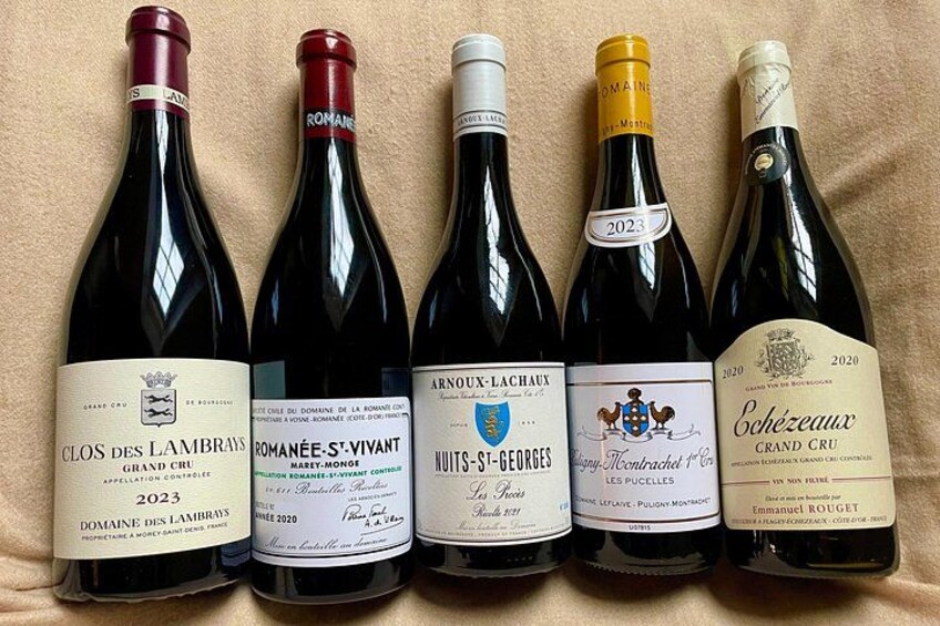 Five wine bottles with labels, arranged in a row. 1