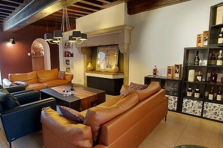A cozy living room with leather sofas, a coffee table, a fireplace, and a wine rack. 5