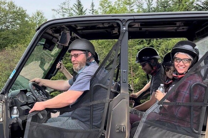 Un vehículo con tres personas, una conduciendo y dos pasajeros. 1