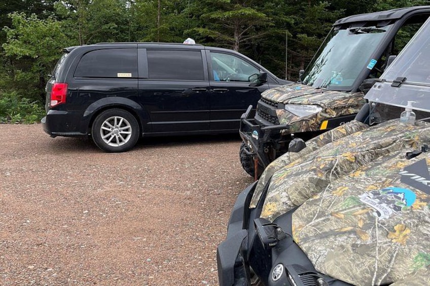 Un SUV negro estacionado sobre una superficie de grava, con un vehículo camuflado en primer plano. 5