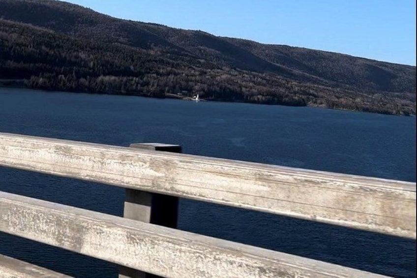 Un puente de madera sobre un lago con montañas al fondo. 3
