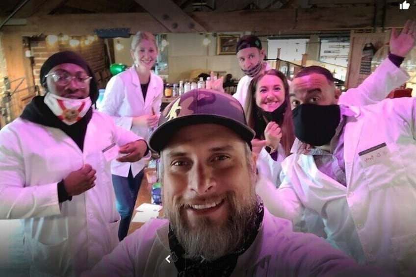 A group of people in white lab coats in an indoor setting with wooden beams on the ceiling. 4