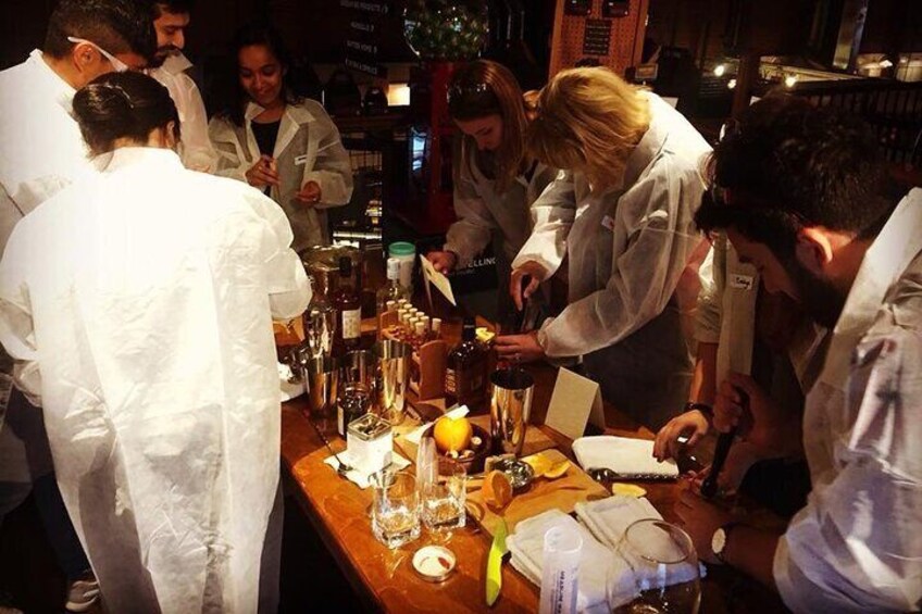 A group of people in white coats preparing drinks at a bar. 3