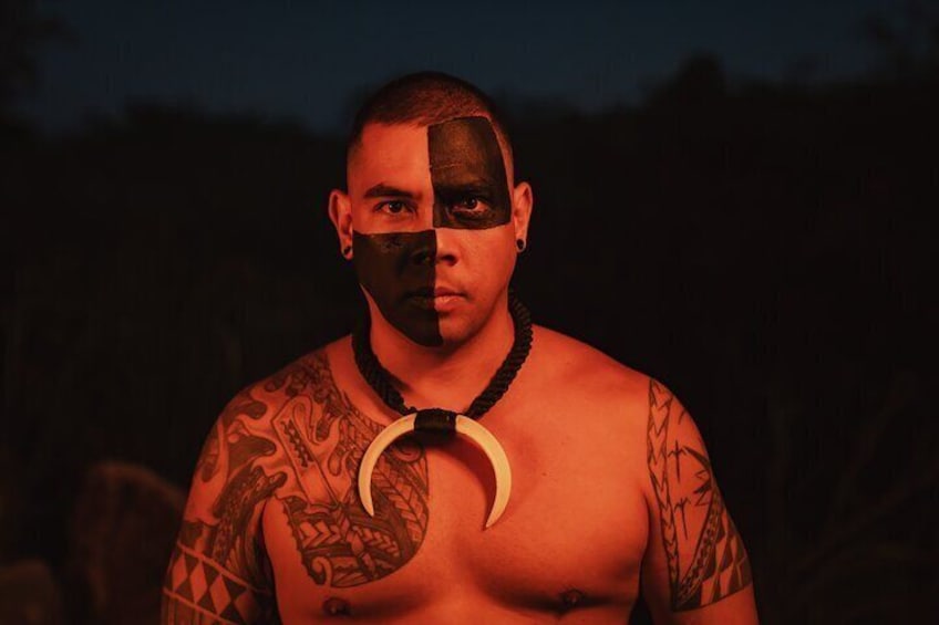 A person with tattoos and a crescent moon pendant. 3
