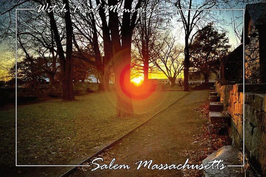 A sunset over a park with a stone wall and a path. 5