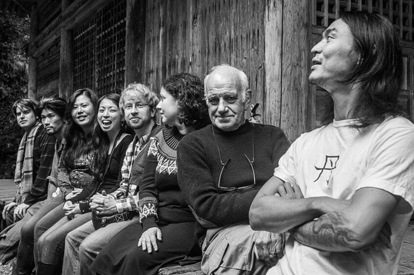 A group of people sitting on a bench outdoors. 3