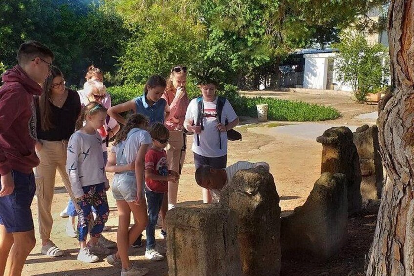 Un groupe de personnes s’est rassemblé autour d’anciennes constructions en pierre dans un parc. 2