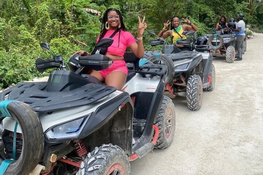 People riding ATVs on a dirt path surrounded by greenery. 5