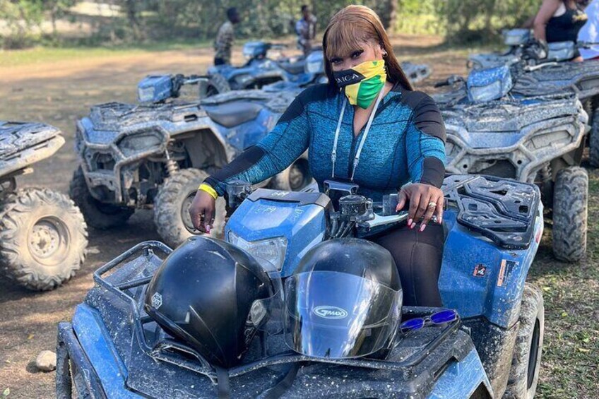 Une personne assise sur un quad bleu, portant un casque et des lunettes de protection. 1