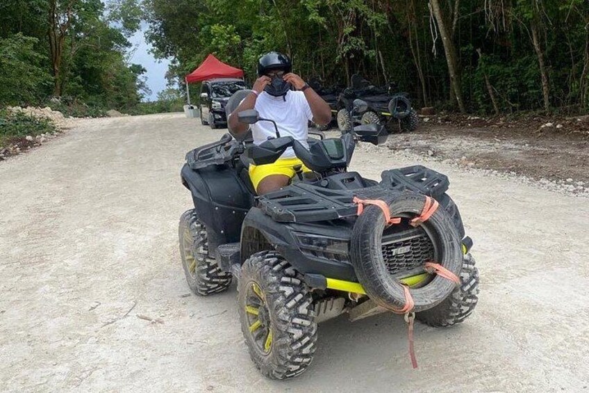 Una persona su un quad con una tenda rossa sullo sfondo. 3