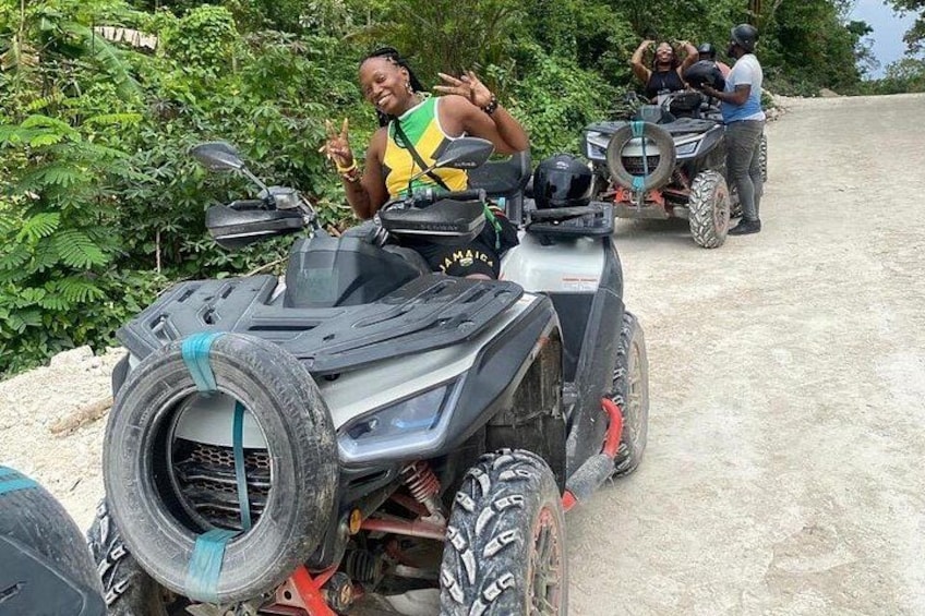 Un gruppo di persone su veicoli ATV, un sentiero sterrato e vegetazione sullo sfondo. 5