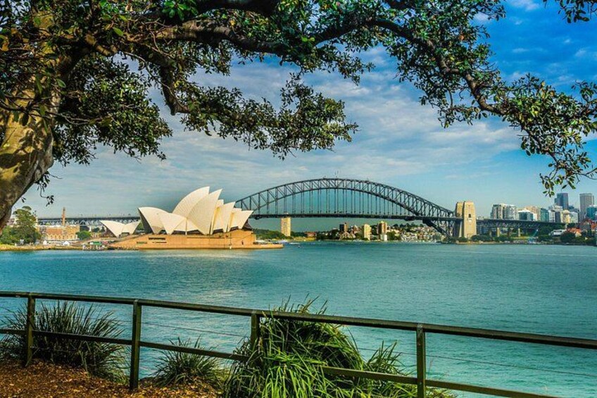 A bridge, a white opera house, and a city skyline across a body of water. 3