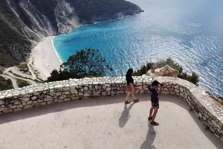 Un paysage côtier avec un sentier en pierre, une plage et une vue dégagée sur la mer. 4
