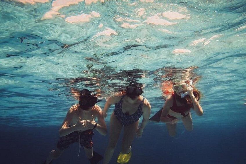 Tres personas haciendo snorkel bajo el agua. 5