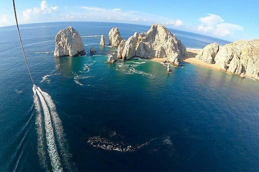 Una barca che naviga vicino a formazioni rocciose in un mare blu limpido. 1