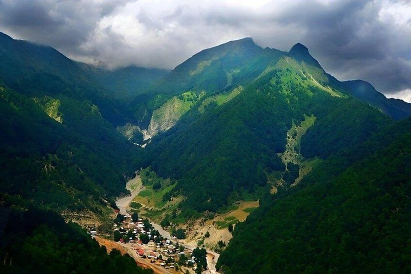 A mountainous landscape with a valley, a river, and a small settlement. 5