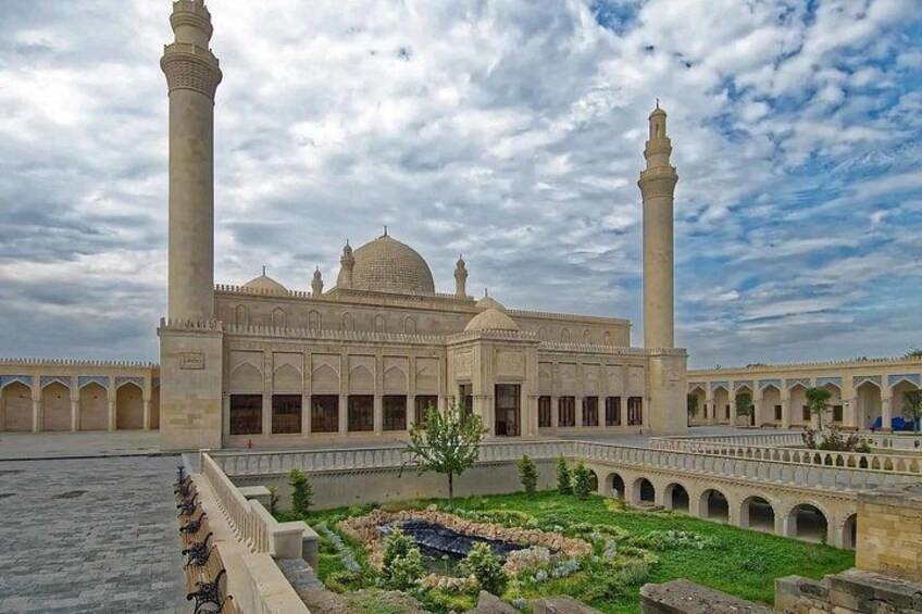 A mosque with two minarets, a large dome, and a courtyard with a fountain. 4