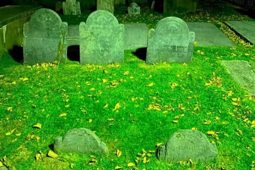 A cemetery with headstones and a grassy area. 2